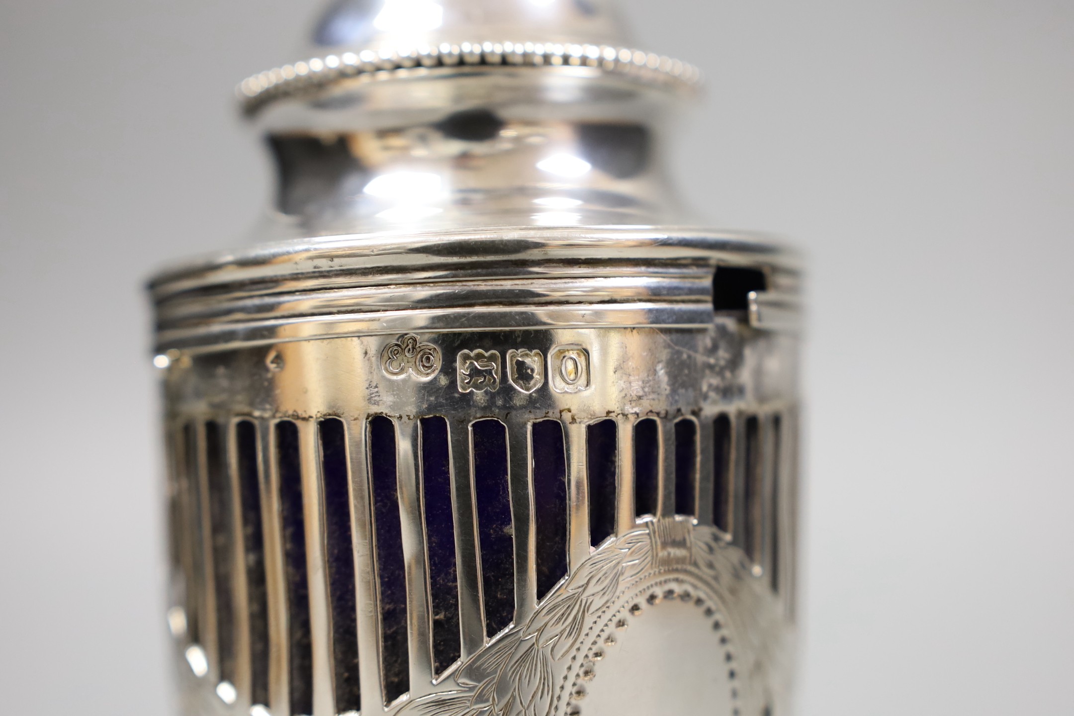 An Edwardian pieced silver vase shaped sugar caster, by Elkington & Co, London, 1909, with blue glass liner, height 14.9cm.